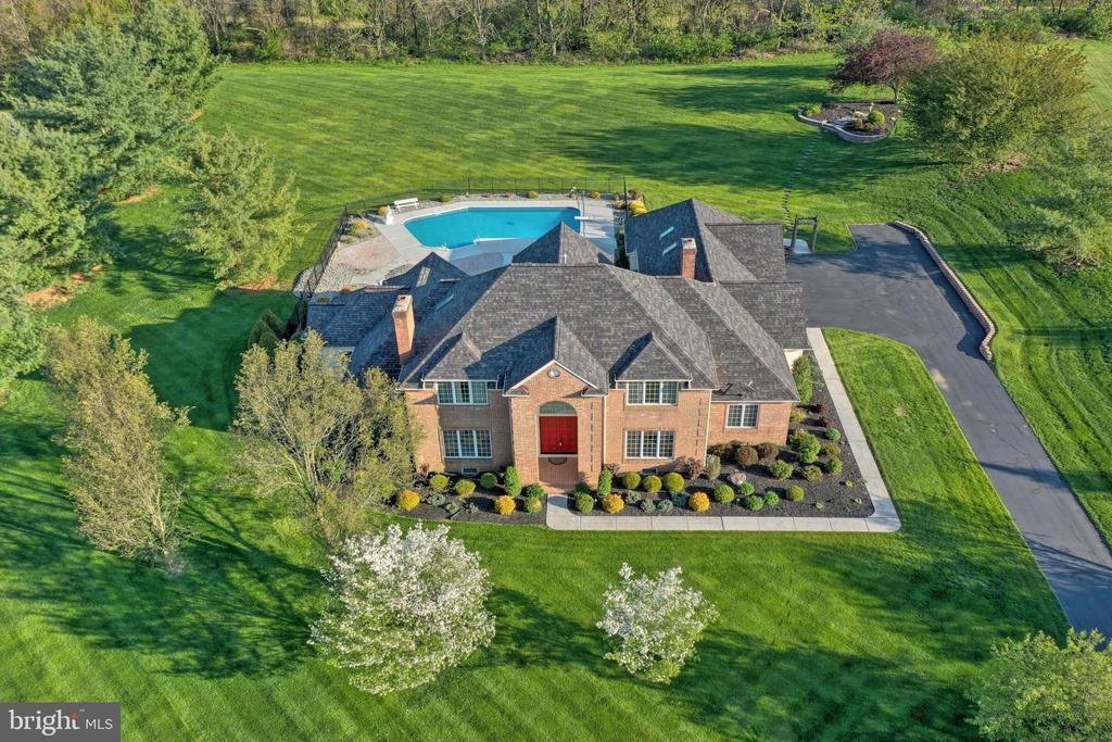A sprawling mansion featuring a central pool, surrounded by grand architecture, showcasing Gettysburg homes for sale luxury living.